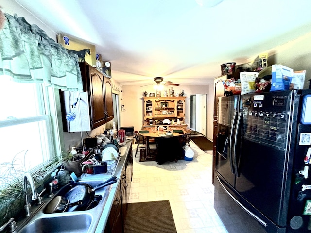3 Rush Blvd, Millinocket, ME 04462 - kitchen with black fridge, a sink, a ceiling fan, dark brown cabinets, and light flooring