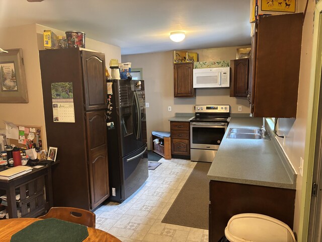 3 Rush Blvd, Millinocket, ME 04462 - kitchen featuring stainless steel electric stove, white microwave, freestanding refrigerator, light flooring, and dark brown cabinets