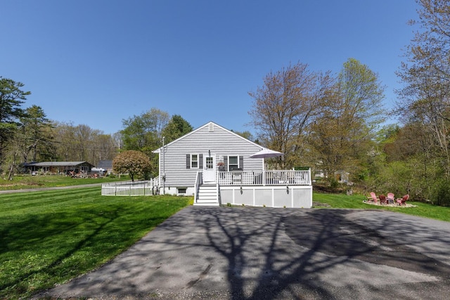 back of property with a deck and a yard