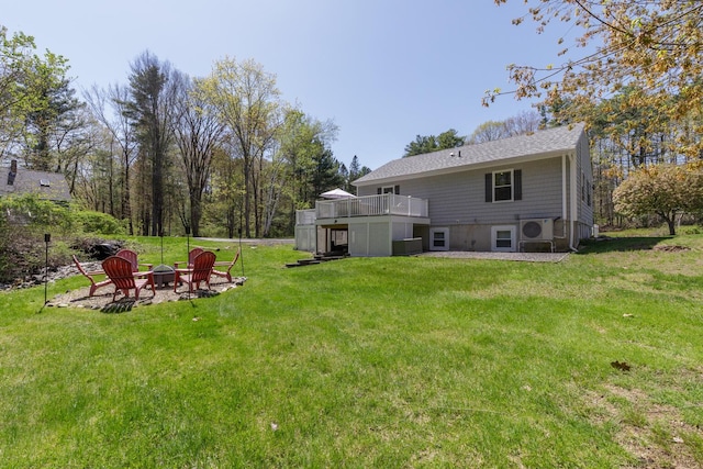 rear view of property with an outdoor fire pit, a yard, and a wooden deck