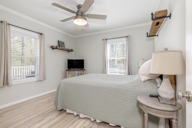 bedroom featuring multiple windows, light wood finished floors, ornamental molding, baseboards, and a ceiling fan