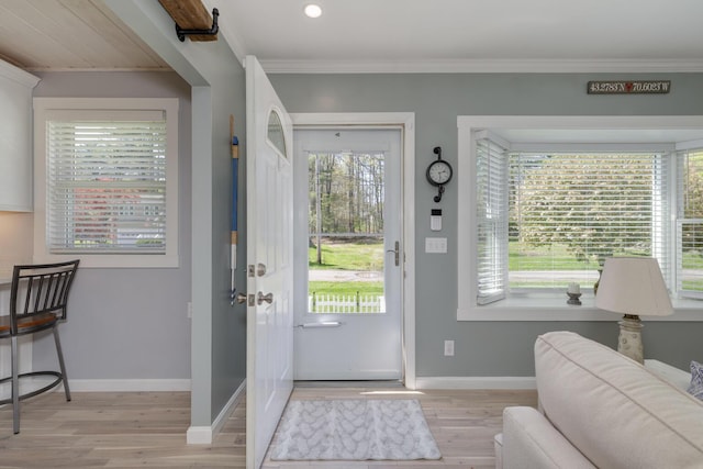 foyer with light wood-style floors, ornamental molding, baseboards, and recessed lighting