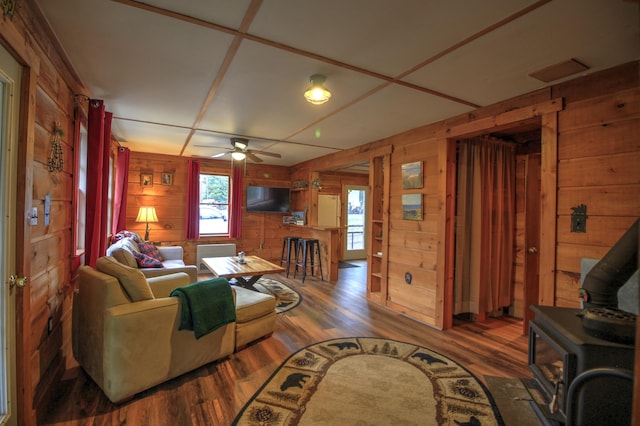 285 Quimby Pond Rd, Rangeley, ME 04970 - living area featuring a wood stove, wood finished floors, wooden walls, and a ceiling fan