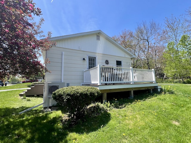 back of house with a deck and a lawn