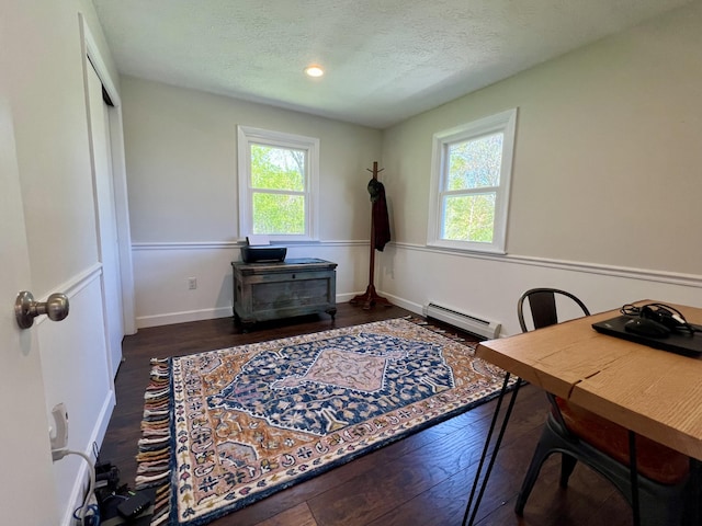 home office with baseboard heating, hardwood / wood-style floors, a textured ceiling, recessed lighting, and baseboards