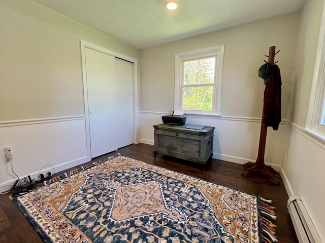 bedroom featuring baseboard heating, dark wood-style flooring, a closet, recessed lighting, and baseboards