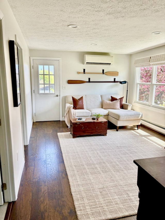 living area with a wall unit AC, a baseboard heating unit, a textured ceiling, and dark wood-style flooring