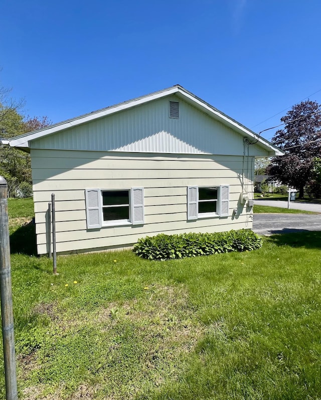 view of side of home with a yard