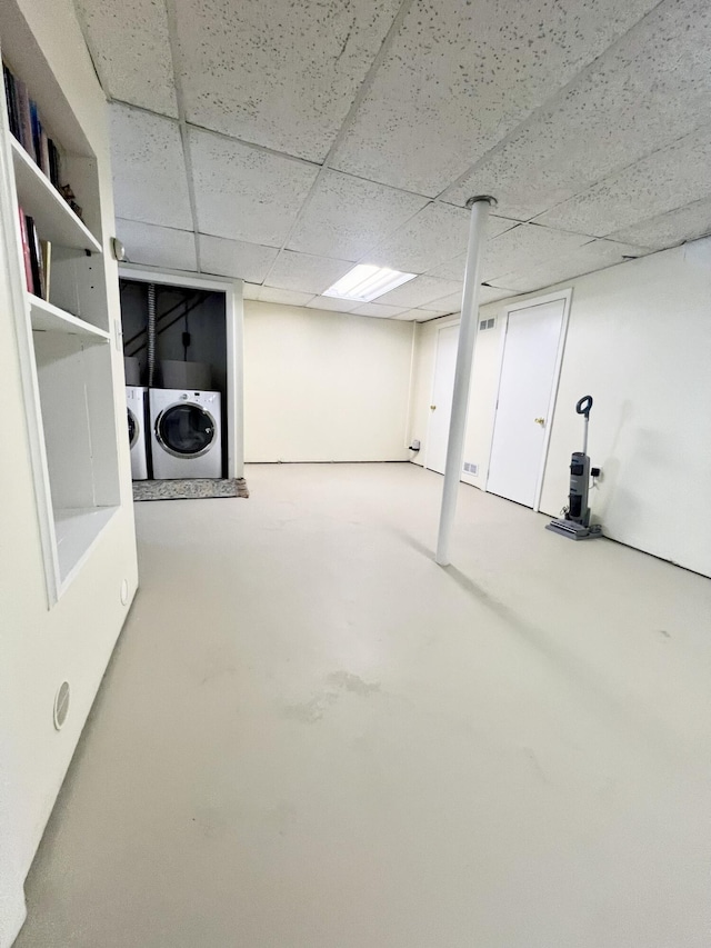 finished basement with a drop ceiling and independent washer and dryer