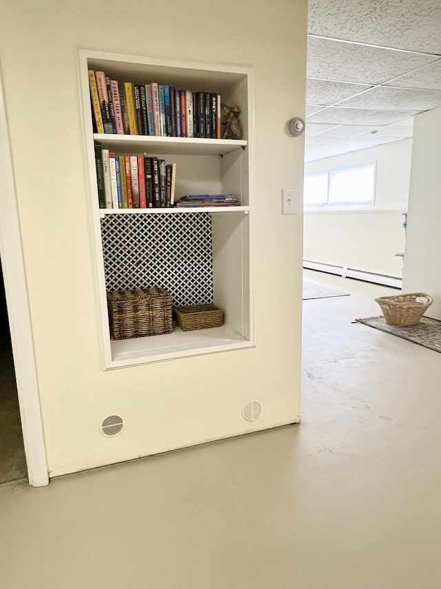 detailed view of baseboard heating and a drop ceiling