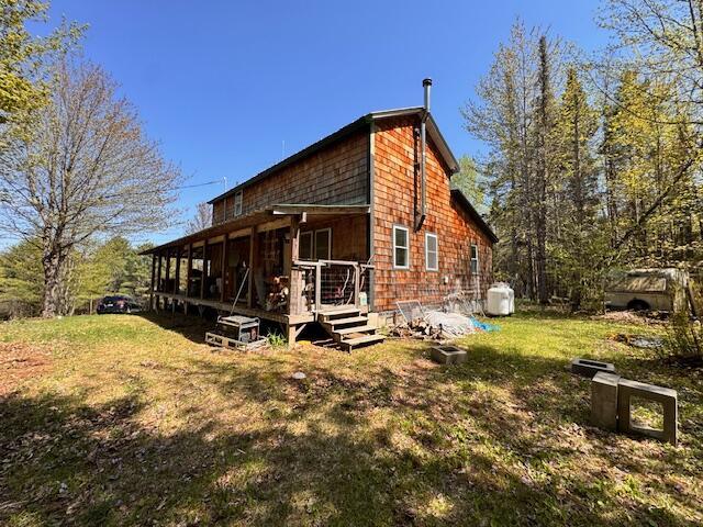 view of property exterior featuring a wooden deck and a lawn