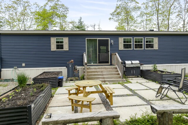 70 Lions Ridge Dr, Alna, ME 04535 - rear view of house with a vegetable garden and a patio