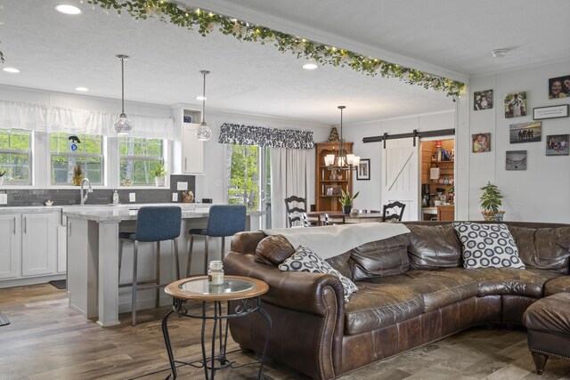 70 Lions Ridge Dr, Alna, ME 04535 - living room featuring a barn door, crown molding, recessed lighting, a textured ceiling, and a chandelier