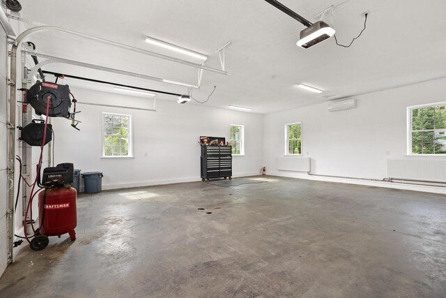 585 Charleston Rd, Charleston, ME 04422 - garage with a garage door opener and a wall unit AC