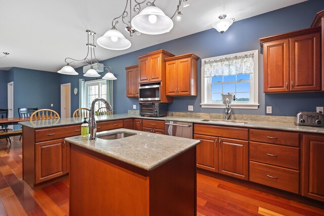 585 Charleston Rd, Charleston, ME 04422 - kitchen featuring stainless steel appliances, a kitchen island with sink, a peninsula, and dark wood-style floors