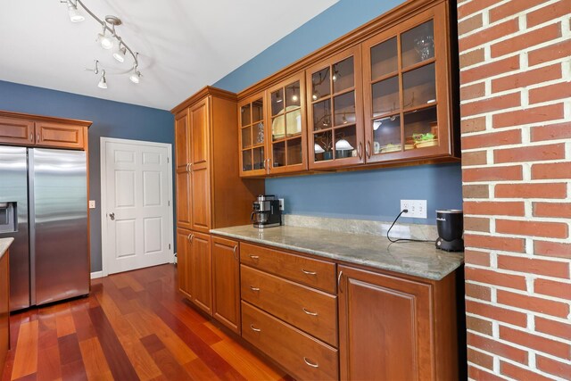 585 Charleston Rd, Charleston, ME 04422 - kitchen featuring stainless steel fridge with ice dispenser, brown cabinets, dark wood finished floors, glass insert cabinets, and light stone countertops
