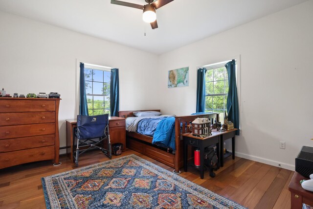 585 Charleston Rd, Charleston, ME 04422 - bedroom featuring multiple windows, wood finished floors, and ceiling fan