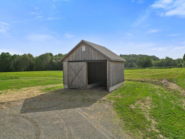 585 Charleston Rd, Charleston, ME 04422 - view of pole building featuring dirt driveway, a lawn, and a wooded view