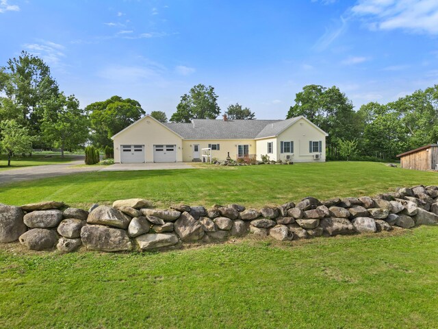 585 Charleston Rd, Charleston, ME 04422 - back of house featuring a lawn, an attached garage, a chimney, and driveway