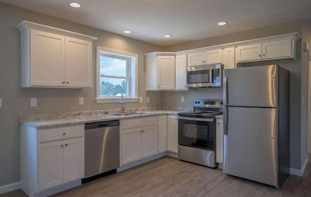 26 Stearns Farm Rd, Hampden, ME 04444 - kitchen featuring stainless steel appliances, a sink, white cabinets, light wood finished floors, and recessed lighting