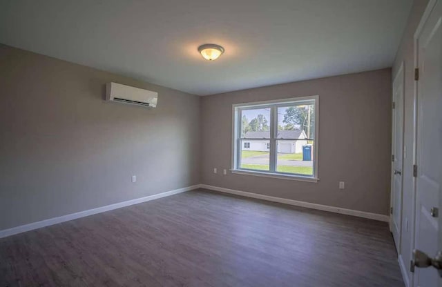 26 Stearns Farm Rd, Hampden, ME 04444 - empty room with a wall unit AC, dark wood-type flooring, and baseboards