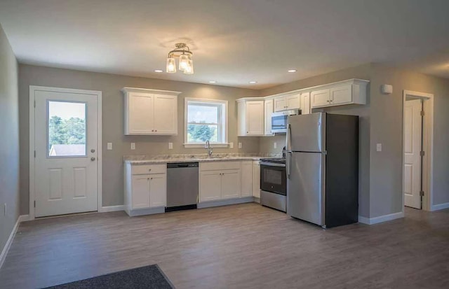 26 Stearns Farm Rd, Hampden, ME 04444 - kitchen featuring appliances with stainless steel finishes, baseboards, light wood-type flooring, light countertops, and white cabinets