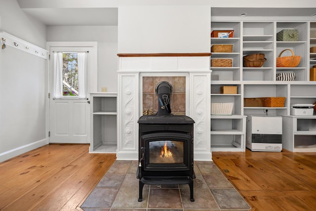 832 Main Rd, Islesboro, ME 04848 - unfurnished living room with a wood stove, wood-type flooring, and baseboards