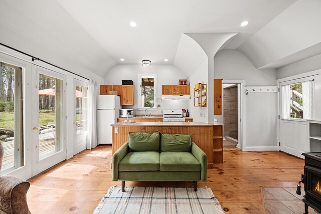 832 Main Rd, Islesboro, ME 04848 - kitchen with white appliances, lofted ceiling, under cabinet range hood, light countertops, and light wood finished floors