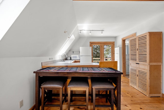 832 Main Rd, Islesboro, ME 04848 - dining room with track lighting, light wood-type flooring, and vaulted ceiling