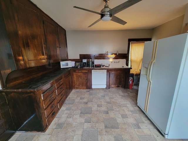 kitchen featuring white appliances, light stone finish floors, ceiling fan, and dark countertops