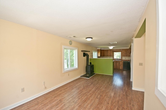 26 Flat Iron Rd, Tremont, ME 04653 - unfurnished living room with a wood stove and dark wood finished floors