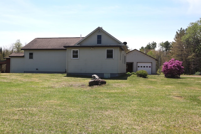rear view of property with a garage, a lawn, and an outdoor structure