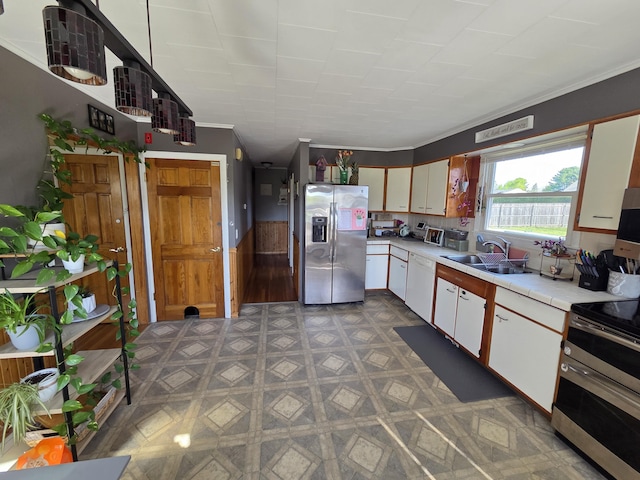 36 Lorraine Ave, Brewer, ME 04412 - kitchen featuring appliances with stainless steel finishes, a sink, crown molding, white cabinetry, and tile countertops