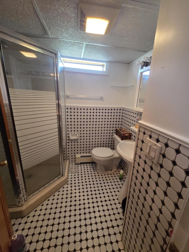36 Lorraine Ave, Brewer, ME 04412 - full bath with a wainscoted wall, a stall shower, tile walls, toilet, and a baseboard heating unit