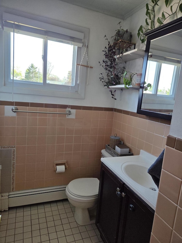 36 Lorraine Ave, Brewer, ME 04412 - bathroom with a baseboard radiator, tile patterned floors, toilet, vanity, and tile walls