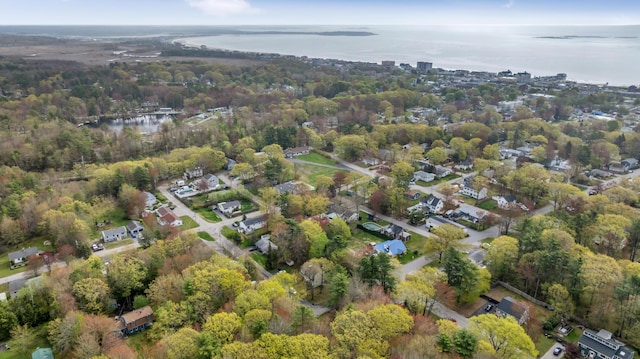 aerial view of property's location featuring a nearby body of water and a heavily wooded area