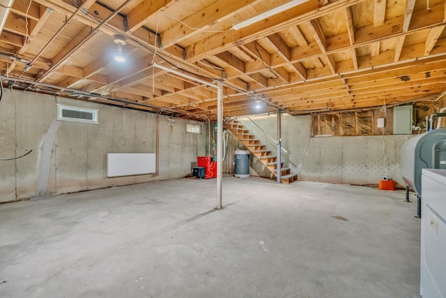 basement with oil tank, stairway, and water heater