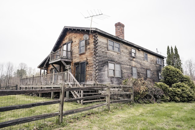 526 Range Rd, Dover-Foxcroft, ME 04426 - view of side of home with a balcony, fence, log siding, and a chimney