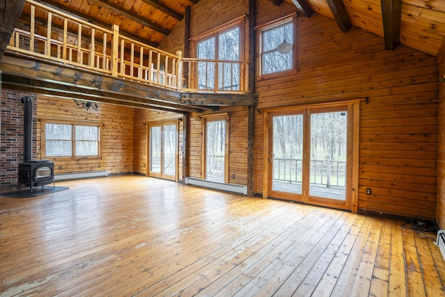 526 Range Rd, Dover-Foxcroft, ME 04426 - unfurnished living room featuring a baseboard heating unit, high vaulted ceiling, beamed ceiling, a wood stove, and hardwood / wood-style floors