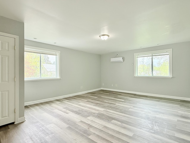 46 French St, Skowhegan, ME 04976 - empty room with an AC wall unit, light wood-type flooring, and baseboards