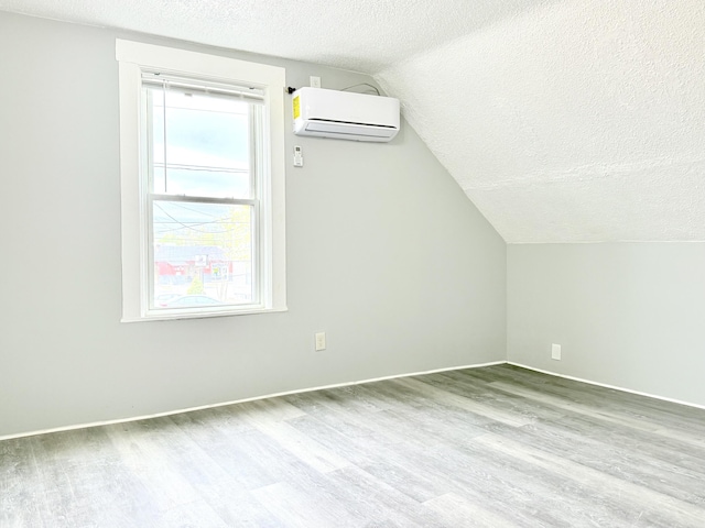 46 French St, Skowhegan, ME 04976 - bonus room with a wall mounted air conditioner, a textured ceiling, wood finished floors, lofted ceiling, and baseboards