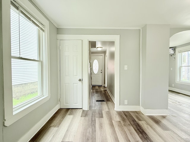 46 French St, Skowhegan, ME 04976 - foyer with arched walkways, light wood-style flooring, baseboards, ornamental molding, and a wall unit AC