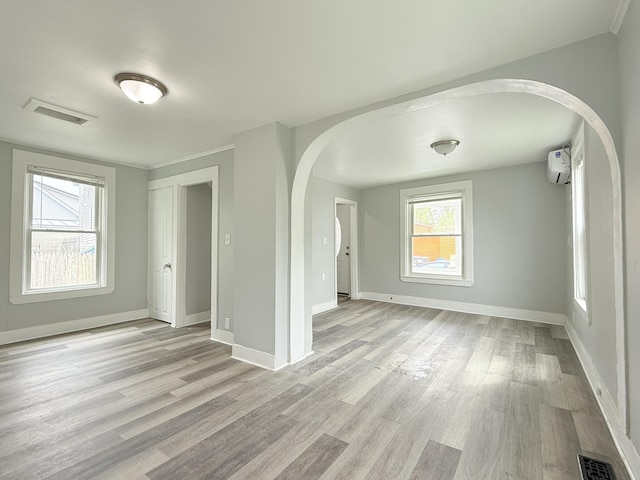 46 French St, Skowhegan, ME 04976 - empty room with arched walkways, light wood-style flooring, baseboards, and a wall mounted AC