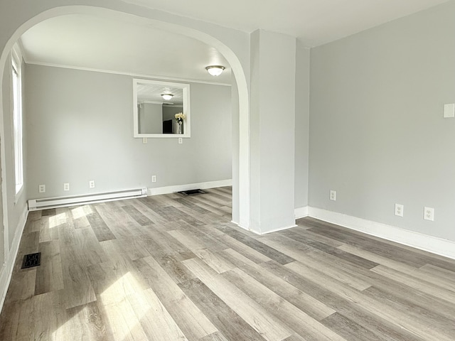 46 French St, Skowhegan, ME 04976 - spare room featuring arched walkways, baseboard heating, wood finished floors, and baseboards