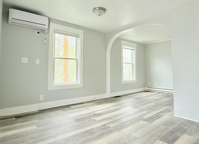 46 French St, Skowhegan, ME 04976 - unfurnished room with a wall mounted air conditioner, arched walkways, baseboard heating, and healthy amount of natural light