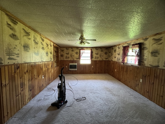7 Thomas Rd, Sangerville, ME 04479 - unfurnished room featuring a wainscoted wall, a ceiling fan, carpet floors, heating unit, and wood walls