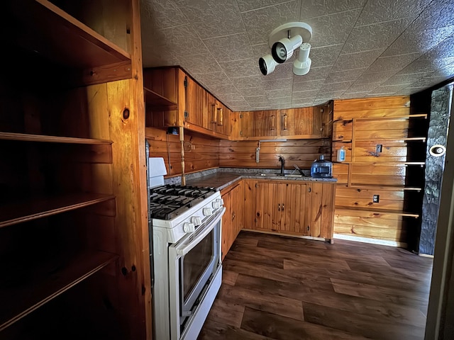 7 Thomas Rd, Sangerville, ME 04479 - kitchen featuring white gas range, a sink, dark countertops, wood walls, and dark wood-style flooring
