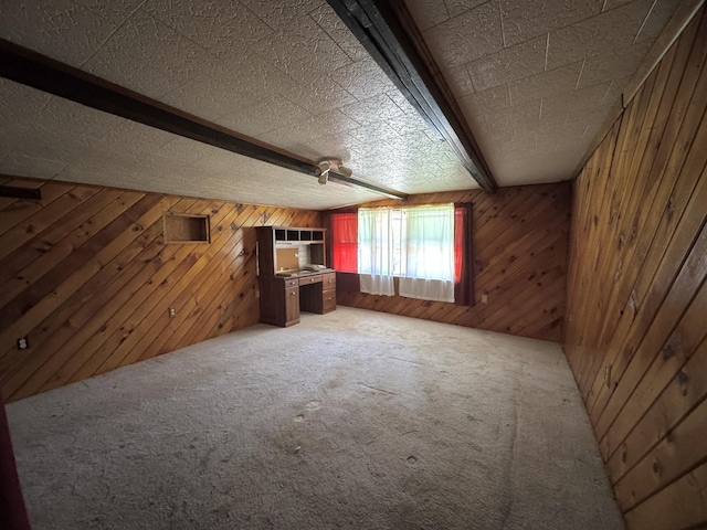 7 Thomas Rd, Sangerville, ME 04479 - unfurnished living room with wooden walls, beam ceiling, and carpet