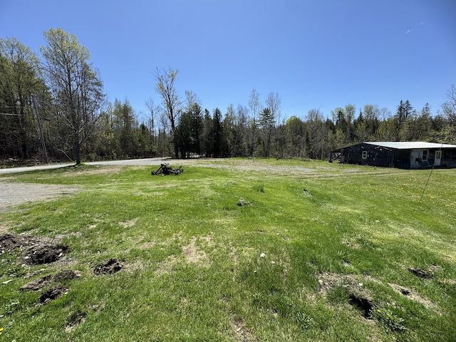 7 Thomas Rd, Sangerville, ME 04479 - view of green lawn featuring a forest view