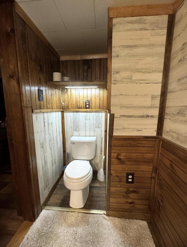 7 Thomas Rd, Sangerville, ME 04479 - bathroom with wood walls, toilet, and wood finished floors